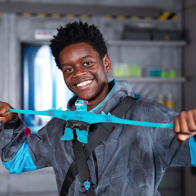 Boy stretching the MrBeast Lab Goo Jit Zu Hypercharged Panther figure in a playful lab setting.