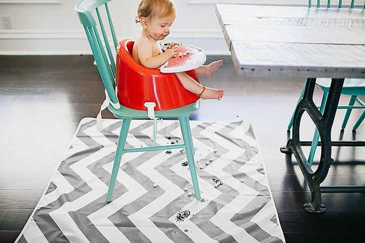 Multi-Use Grey Floor Mat under highchair, catching messes in play area with a child enjoying food.
