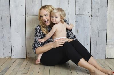 Kit and Kin Biodegradable Nappy Sacks - Mother and toddler sitting together on wooden floor, smiling happily, enjoying quality time.